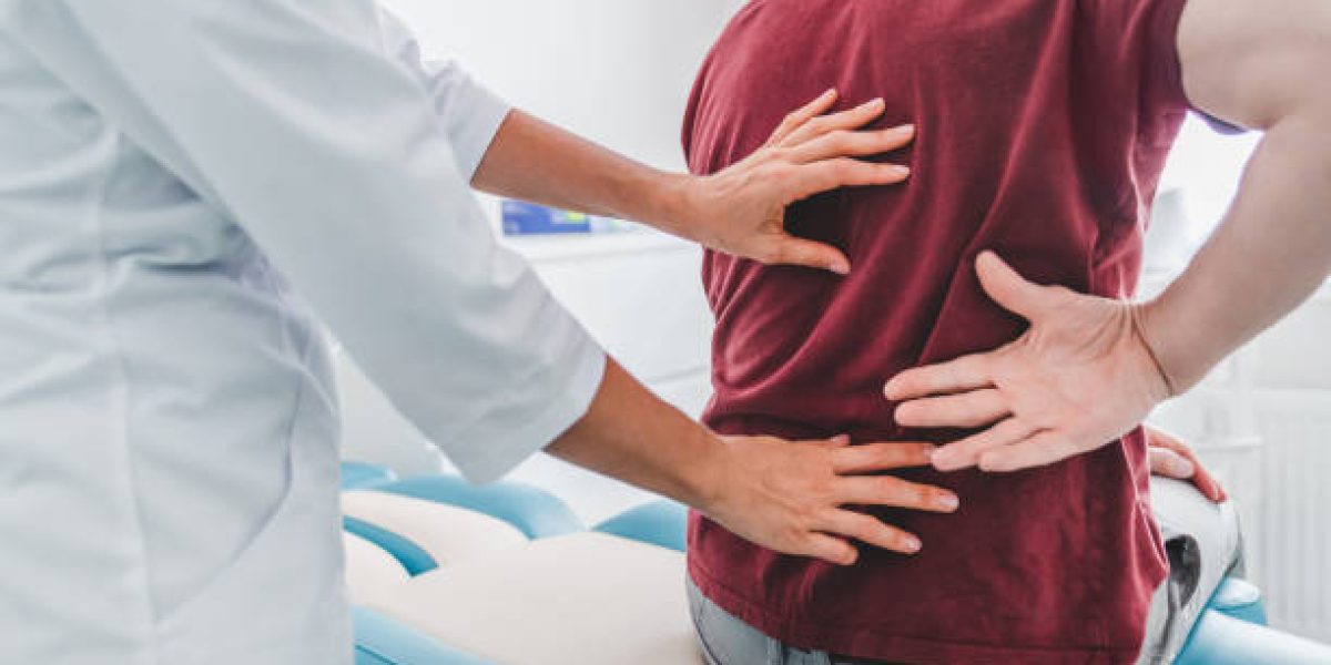 Cropped close up of female orthopedist examining patient's back in clinic